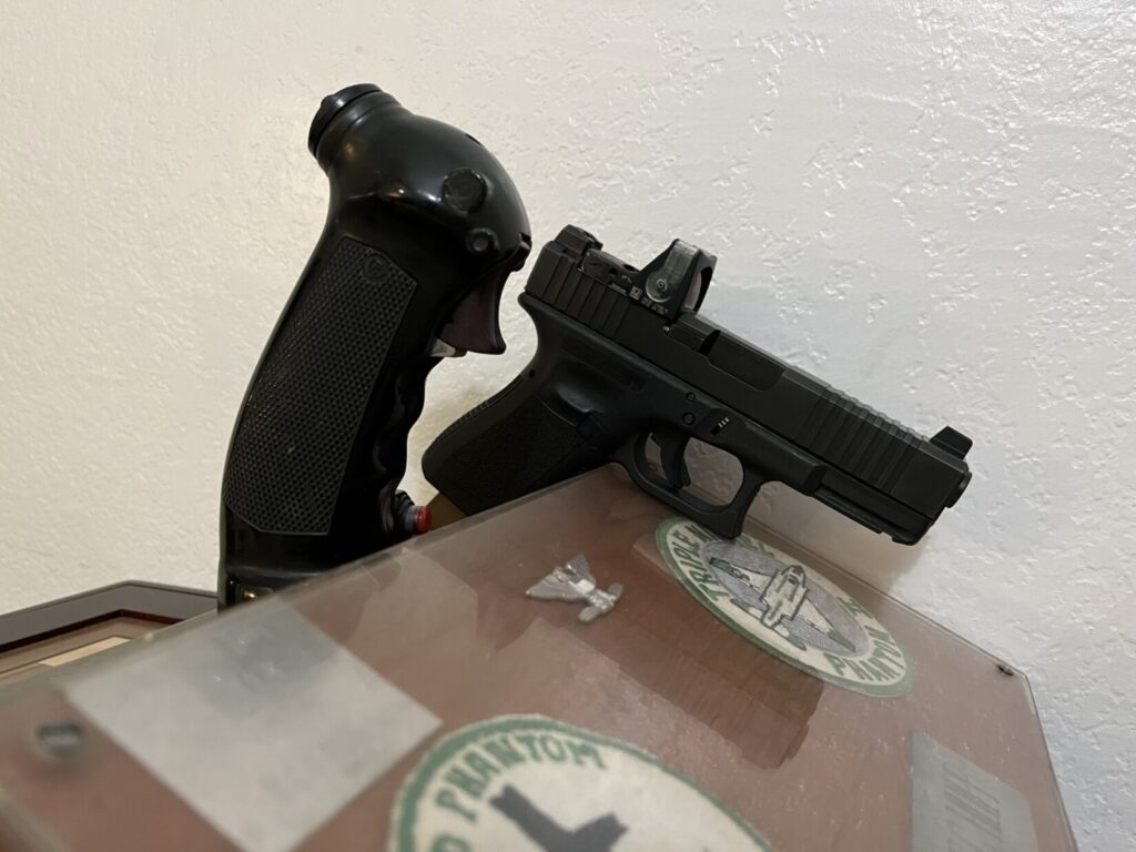 A fighter stick and a pistol, showing the triggers on both.