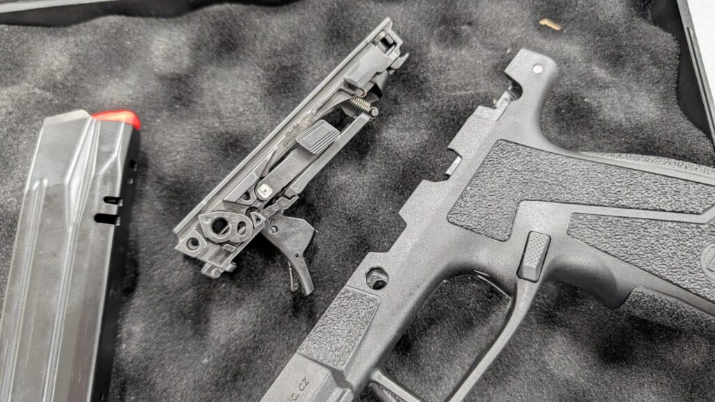 Disassembled CZ DUTY pistol showing the empty polymer grip module, the removable serialized chassis, and a magazine