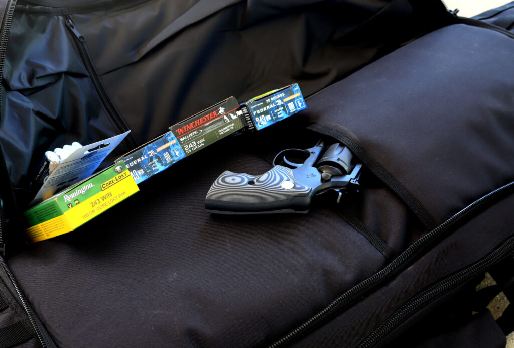Outer compartment of the Safariland Dual Rifle Bag holding ammunition boxes and a Colt Python revolver